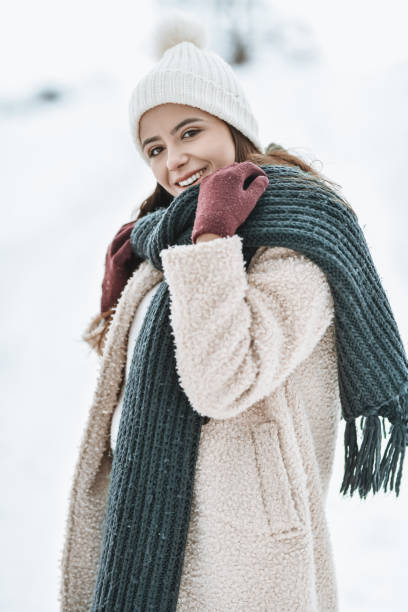 Portrait of female beauty in warm clothing enjoying mountain snow holiday